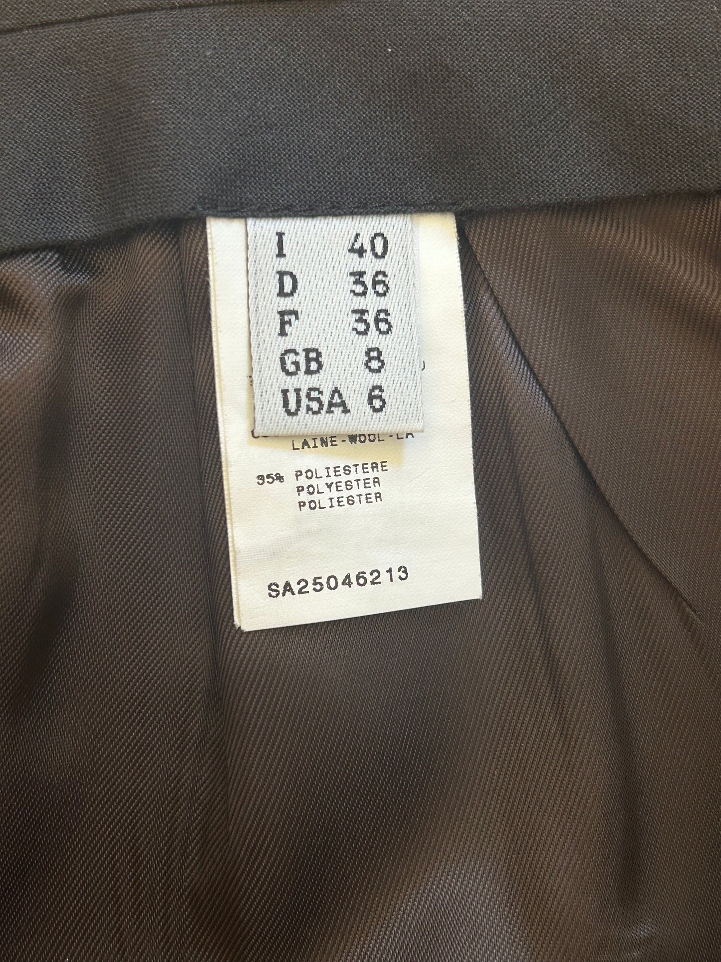 Interior label of the 1993/94 Hiver Re Edition Collection Jean Paul Gaultier wool pencil skirt, showing size details (I 40, GB 8, USA 6) and fabric composition (65% wool, 35% polyester). A collectible piece showcasing the designer's meticulous attention to detail.