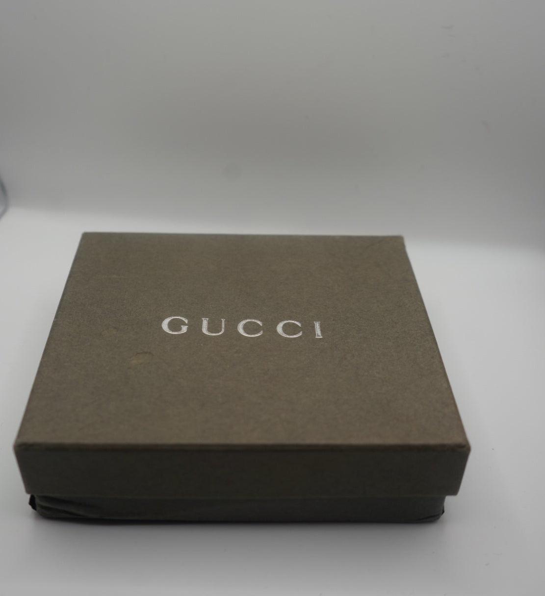 Angled view of Green Gucci Wallet box showing silver text logo.
