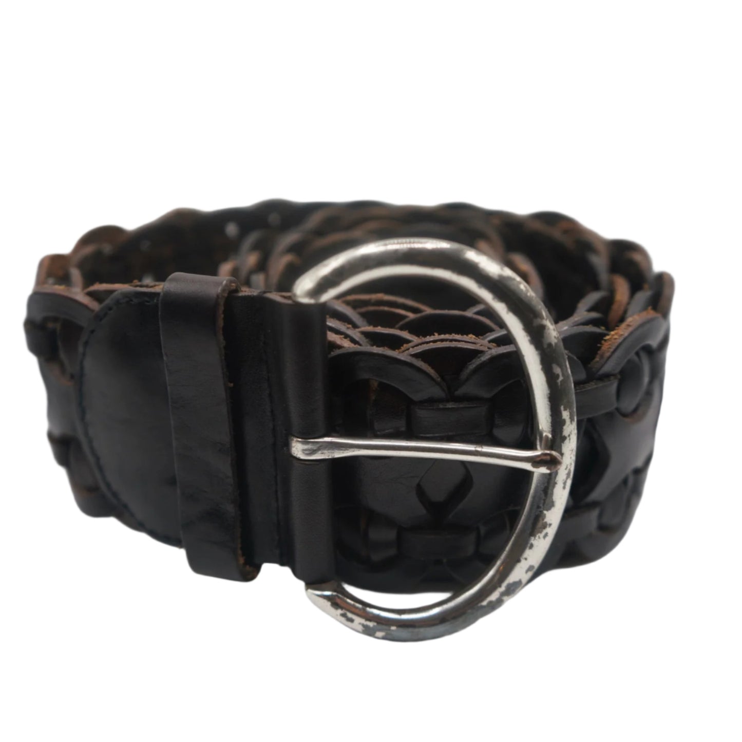 A close-up view of a vintage black leather woven belt with a silver buckle. The belt is coiled, showcasing its intricate braided design and worn, rustic finish. The buckle is circular and slightly tarnished, adding to the belt's aged yet stylish appearance.