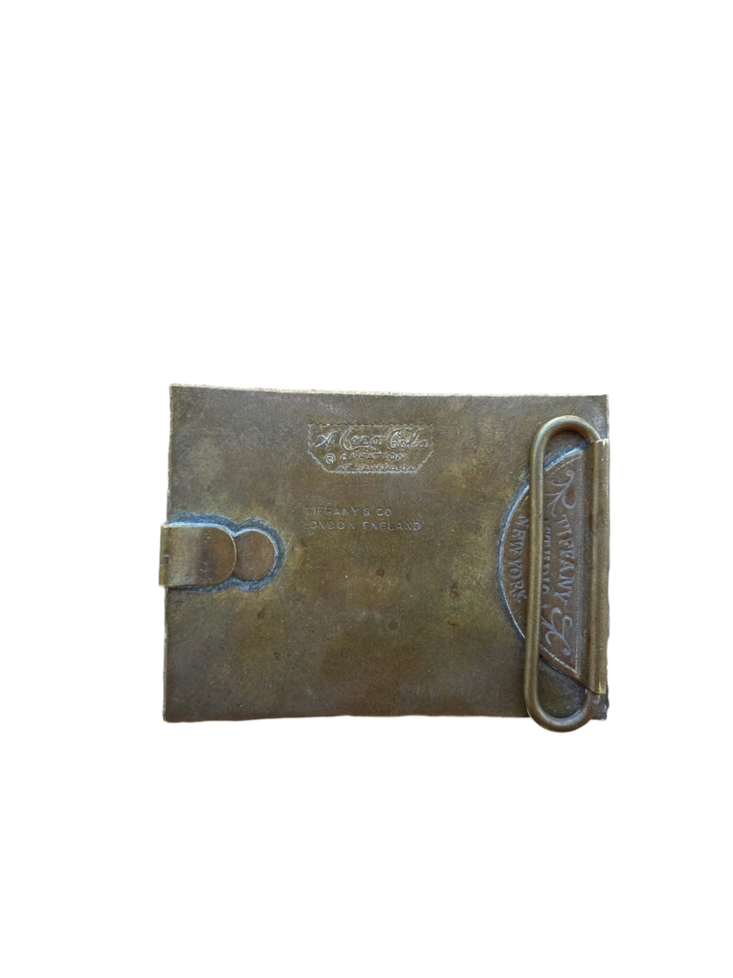 Rear detail of the 1970s Coca-Cola belt buckle by Tiffany & Co., featuring engraved markings for 'Tiffany Studio New York' and 'London England,' emphasizing its authenticity and collectible value.