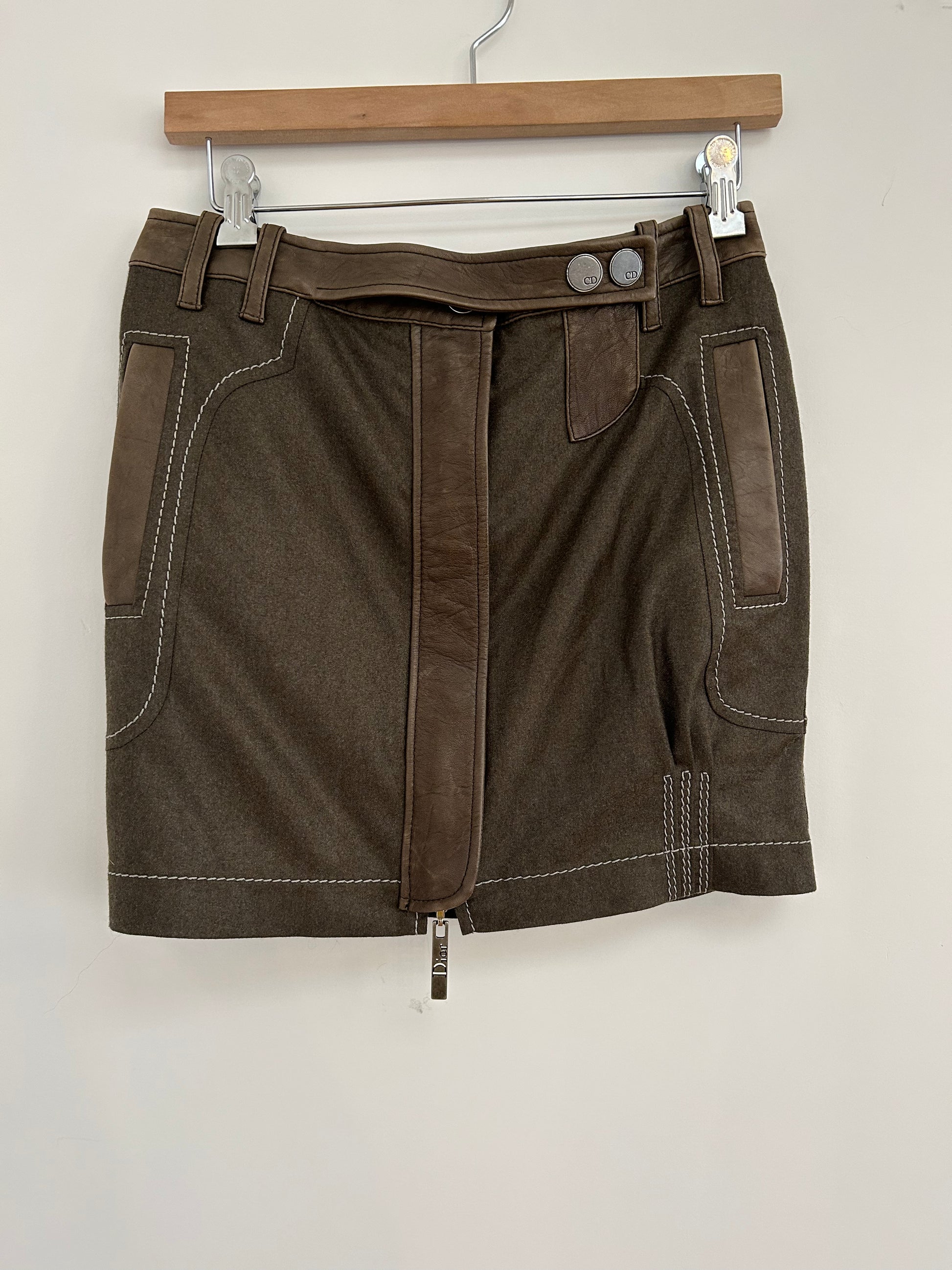 Front view of a 2000s Christian Dior wool and lambskin mini skirt, featuring leather accents, white contrast stitching, and a Dior-branded zipper. A luxurious and modern piece showcasing timeless Dior craftsmanship.