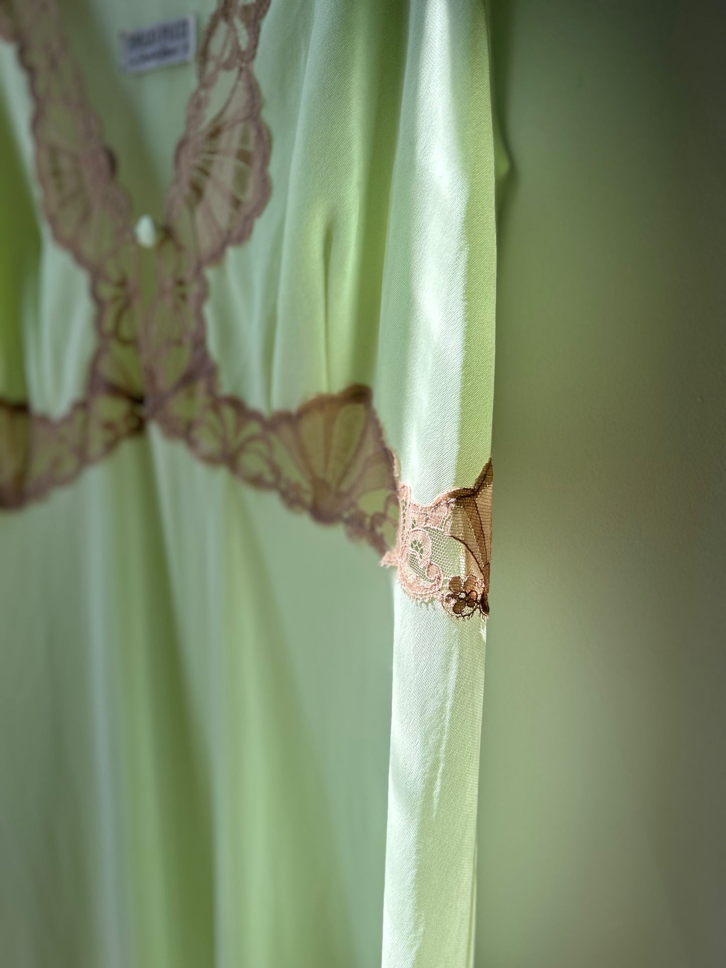 Close-up of a 1960s Emilio Pucci sheer slip in soft green with intricate lace accents, embodying vintage elegance and timeless luxury. A rare and iconic piece for lovers of sustainable and high-fashion history.