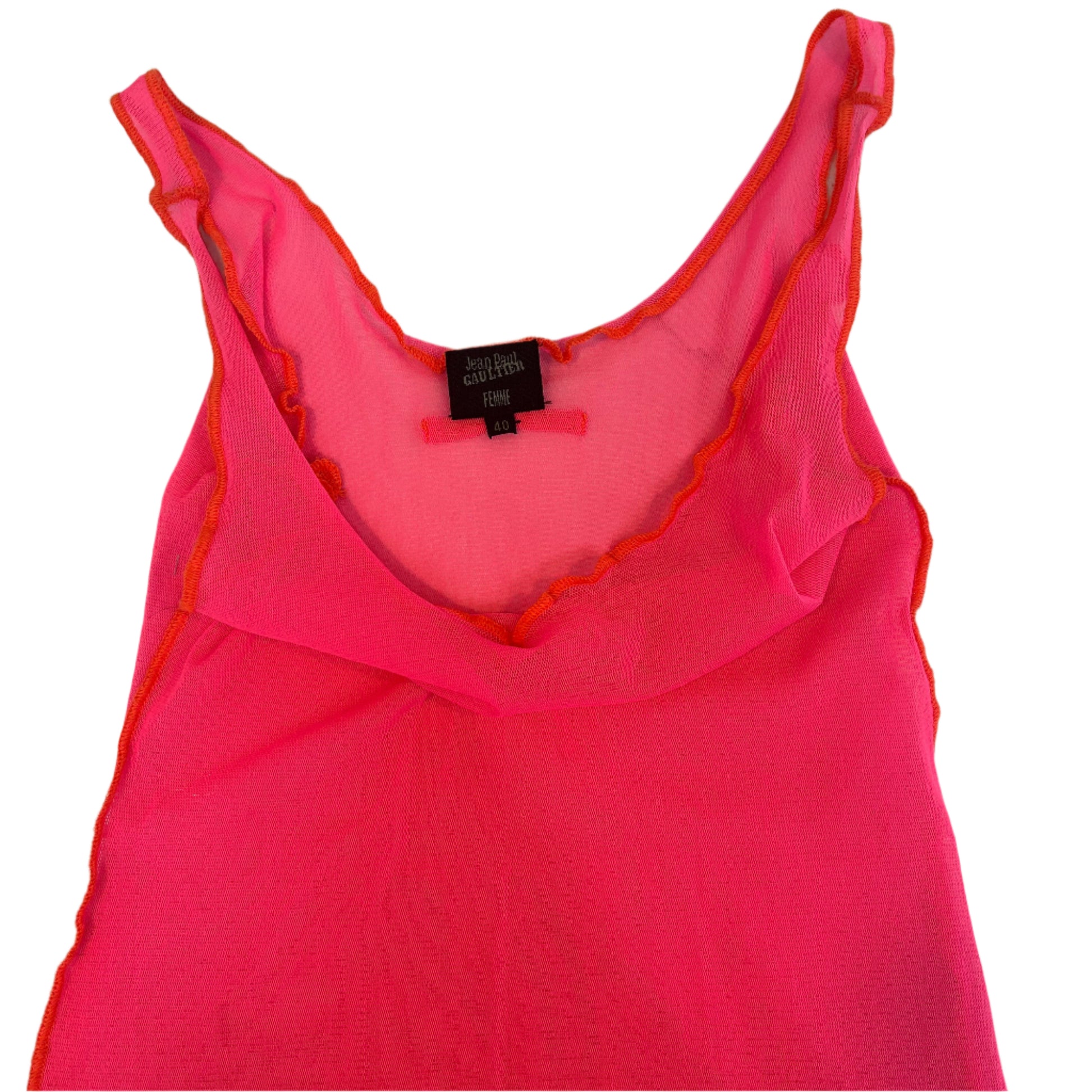 Close-up of a 1990s Jean Paul Gaultier mesh tank top in vibrant pink with orange trim and a ruffled neckline. A bold and iconic piece exemplifying the avant-garde style of the renowned designer.