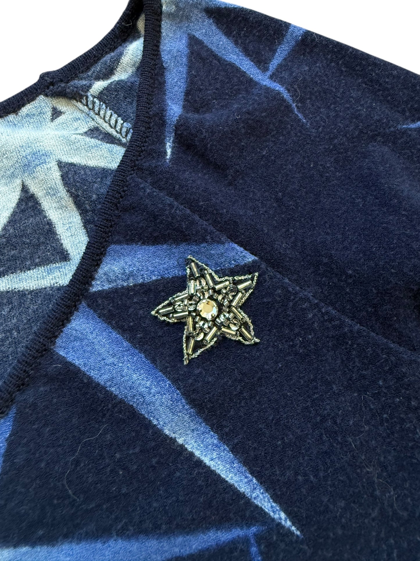Navy blue fabric with a star-shaped brooch