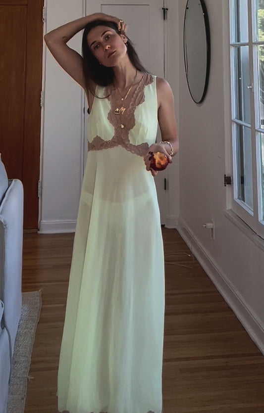 Video of a model wearing a 1960s Emilio Pucci sheer slip in pale green, showcasing its elegant fit, intricate lace details, and timeless vintage charm. Perfect for highlighting sustainable luxury and the beauty of historical fashion in motion.